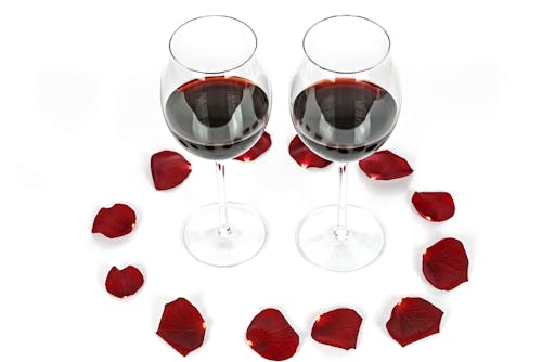 Two Wine-filled Glasses Surrounded by Petals