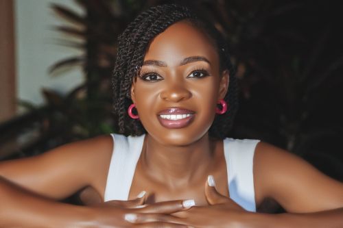 Free A vibrant portrait of a smiling woman with braided hair and pink earrings, radiating joy. Stock Photo