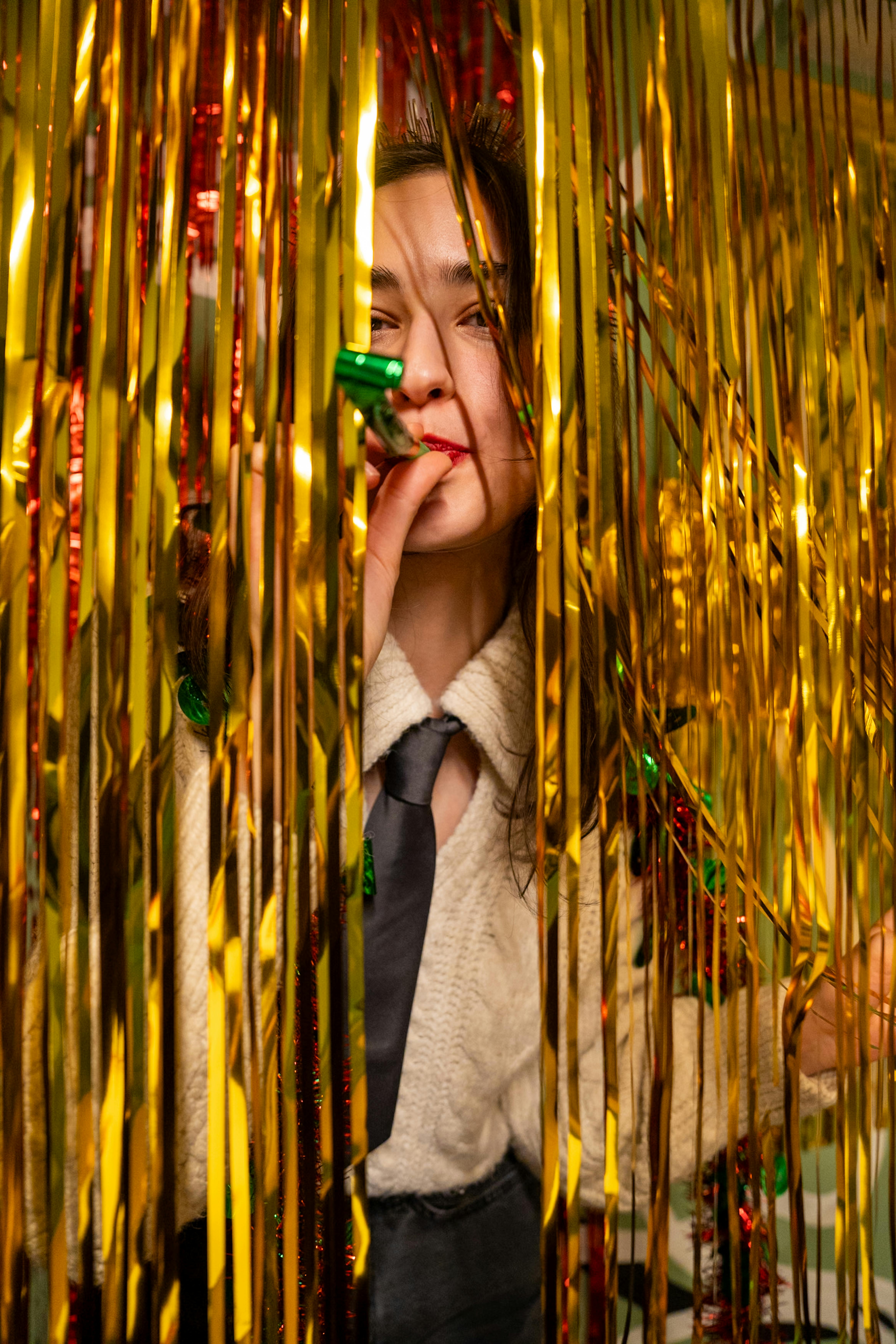 Gratuit Une femme joyeuse célébrant avec des banderoles dorées et une corne de fête, capturant l'esprit festif. Photos