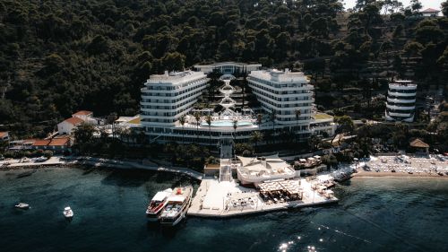 Free Stunning aerial view of a modern resort surrounded by lush greenery and clear waters in Lopud, Croatia. Stock Photo