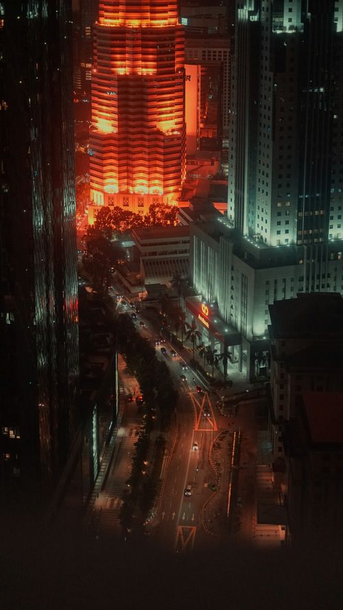 Free Aerial view of Kuala Lumpur's illuminated skyline at night, showcasing vibrant city lights. Stock Photo