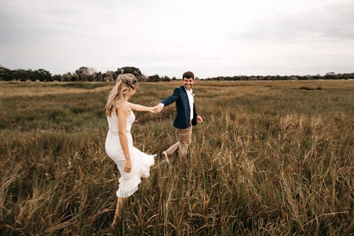 Pareja feliz caminando por campo abierto