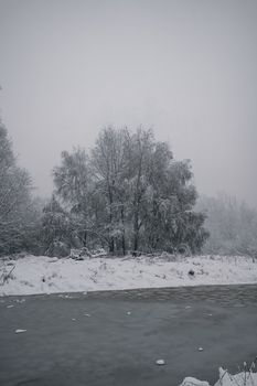 Beautiful snowy scene in Jammu and Kashmir with trees and river.