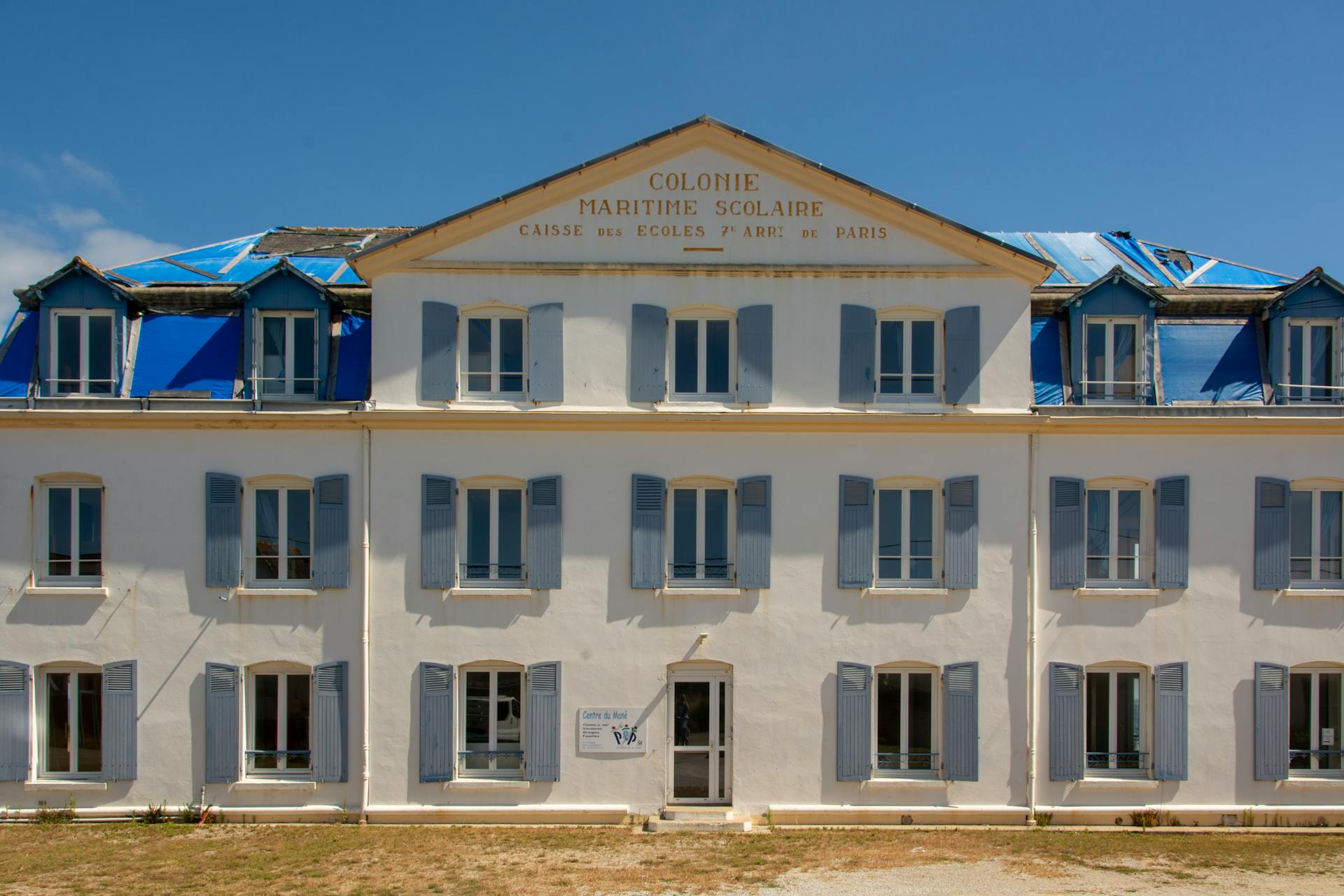 Photo of a historic maritime school facade under restoration in Quiberon, France.