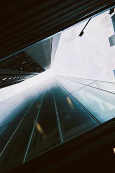 Dramatic shot of a skyscraper from below with a cloudy sky overhead.