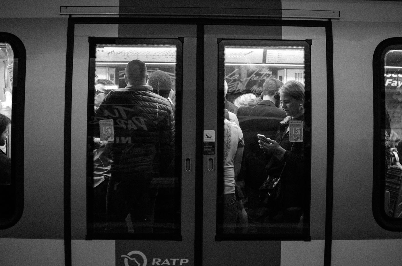 Passagers du métro parisien absorbés par leurs téléphones
