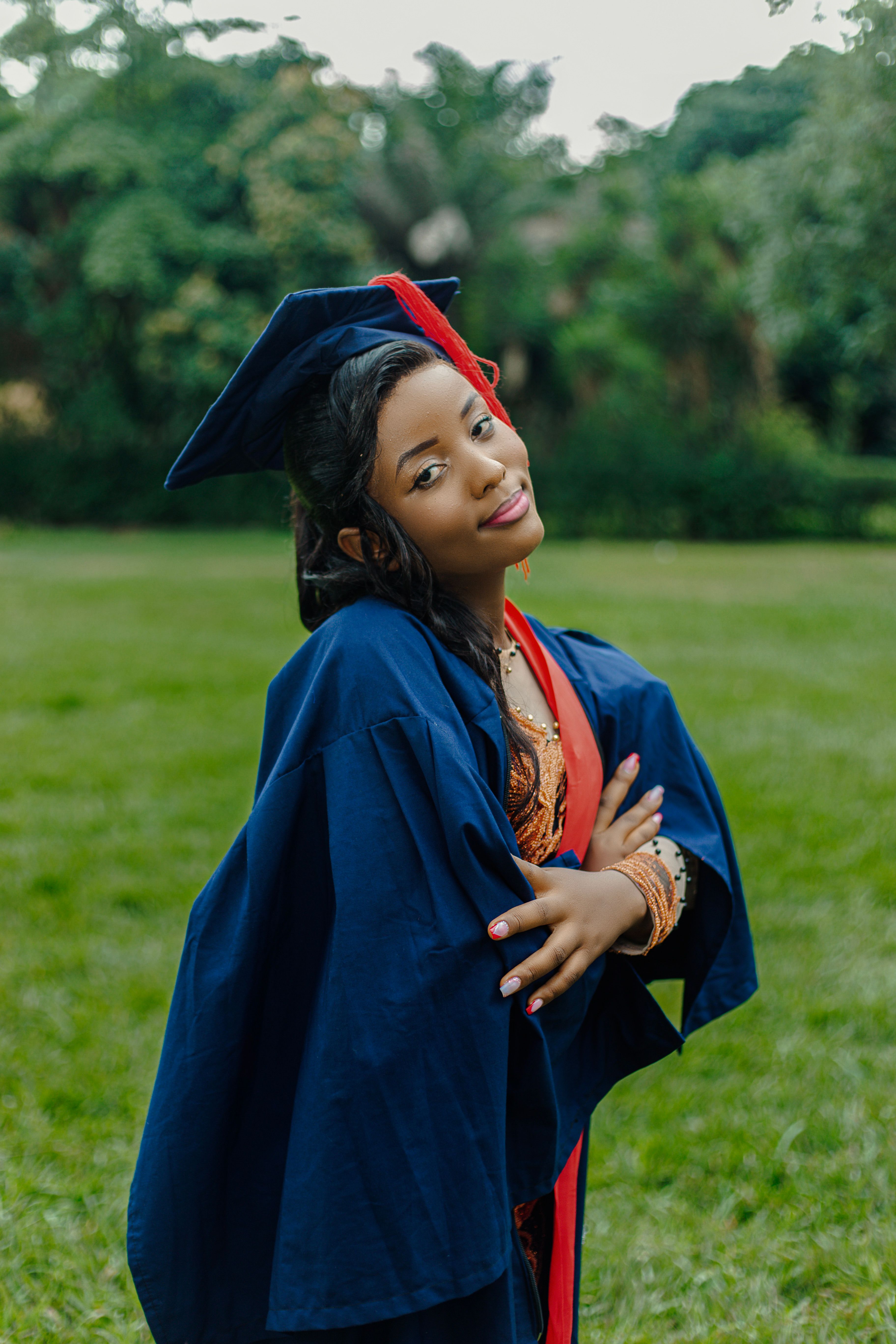 Joyful graduate in a cap and gown outdoors · Free Stock Photo