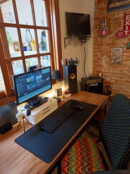 Home office with brick wall, computer, and vintage decor, perfect for work-from-home inspiration.