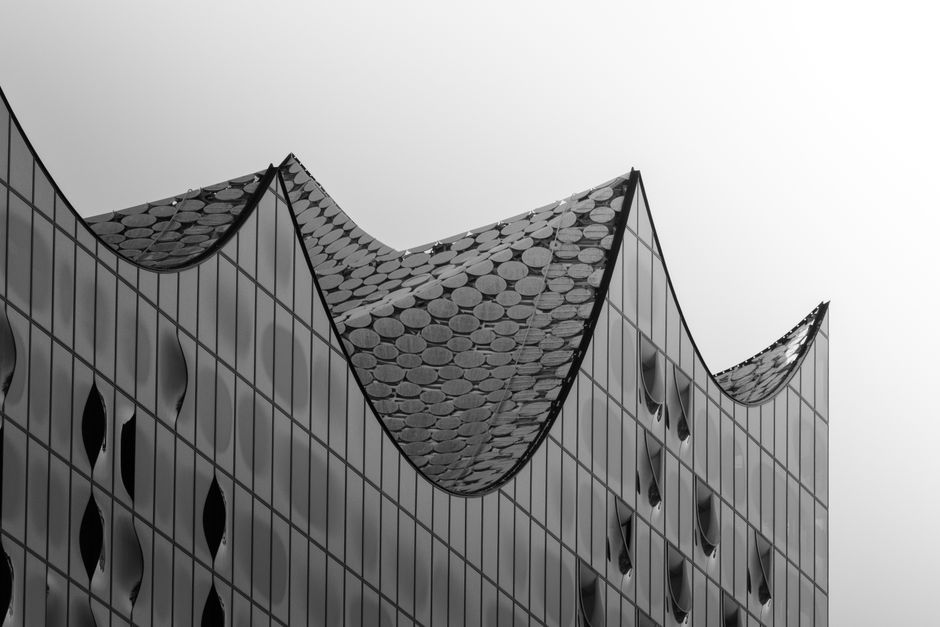 Monochrome image of Elbphilharmonie's curved glass facade in Hamburg, Germany.