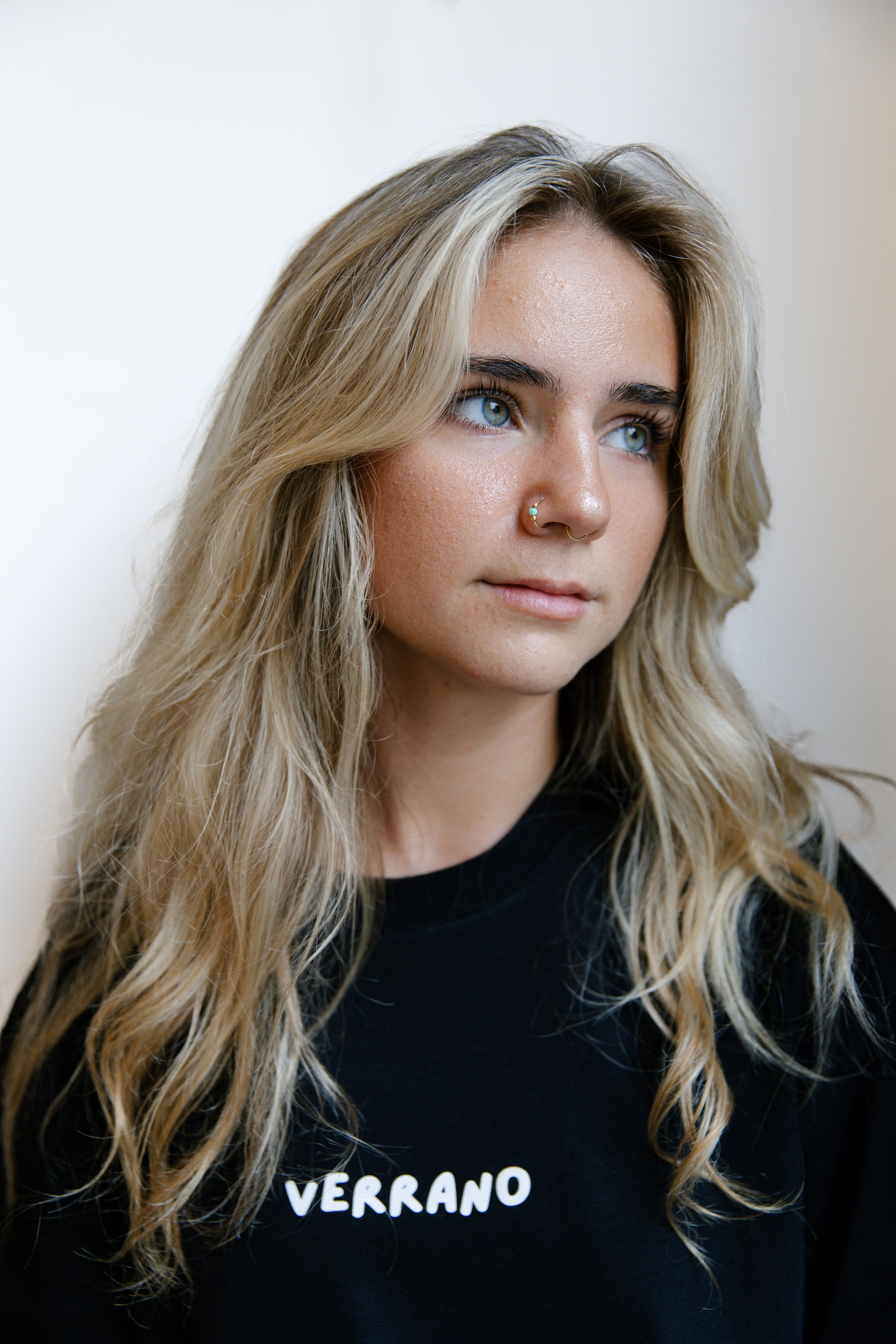 Close-up portrait of a young woman with blonde hair and thoughtful expression.