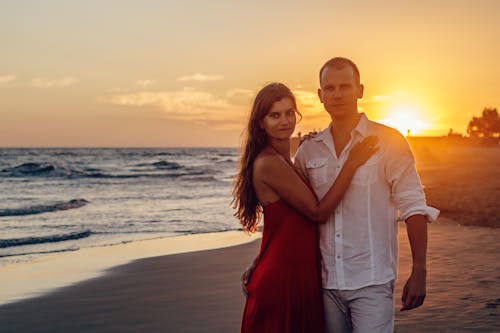 Free Woman Standing Beside Man Near Shoreline Stock Photo