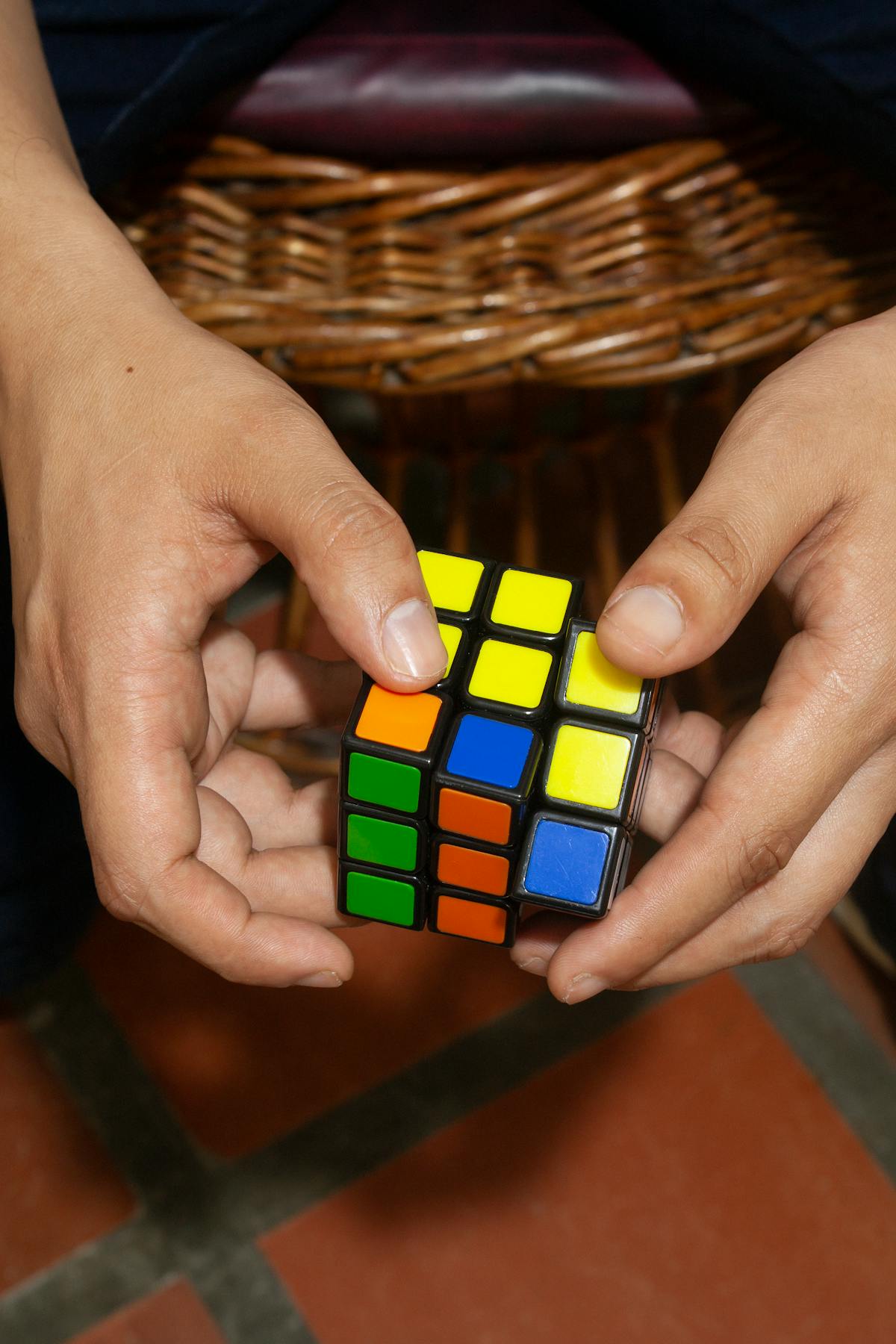 Primo piano di mani che ruotano un Cubo di Rubik colorato