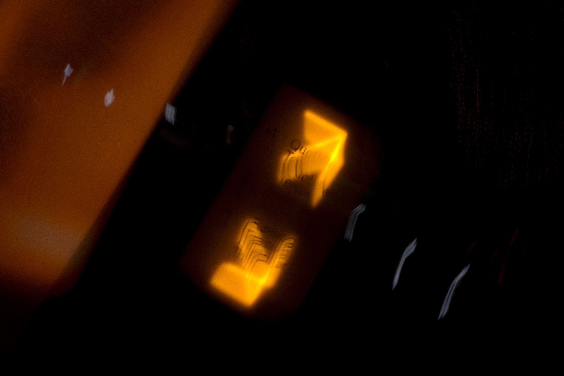 Dynamic abstract image of blurred orange and yellow light streaks in a dark setting.