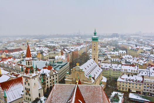Aerial view of Munich's historic architecture covered in snow during winter, highlighting Germany's Bavarian beauty.