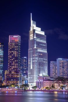 A striking urban skyline illuminated at night, displaying modern architecture.