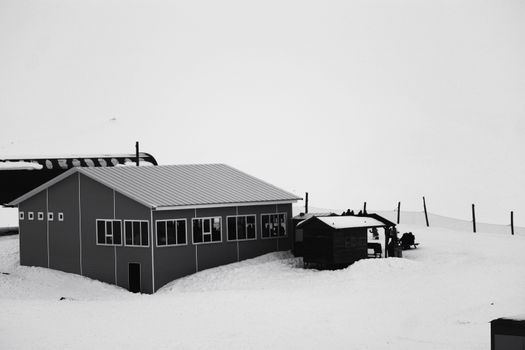 Isolated building in snow-covered landscape during winter season.