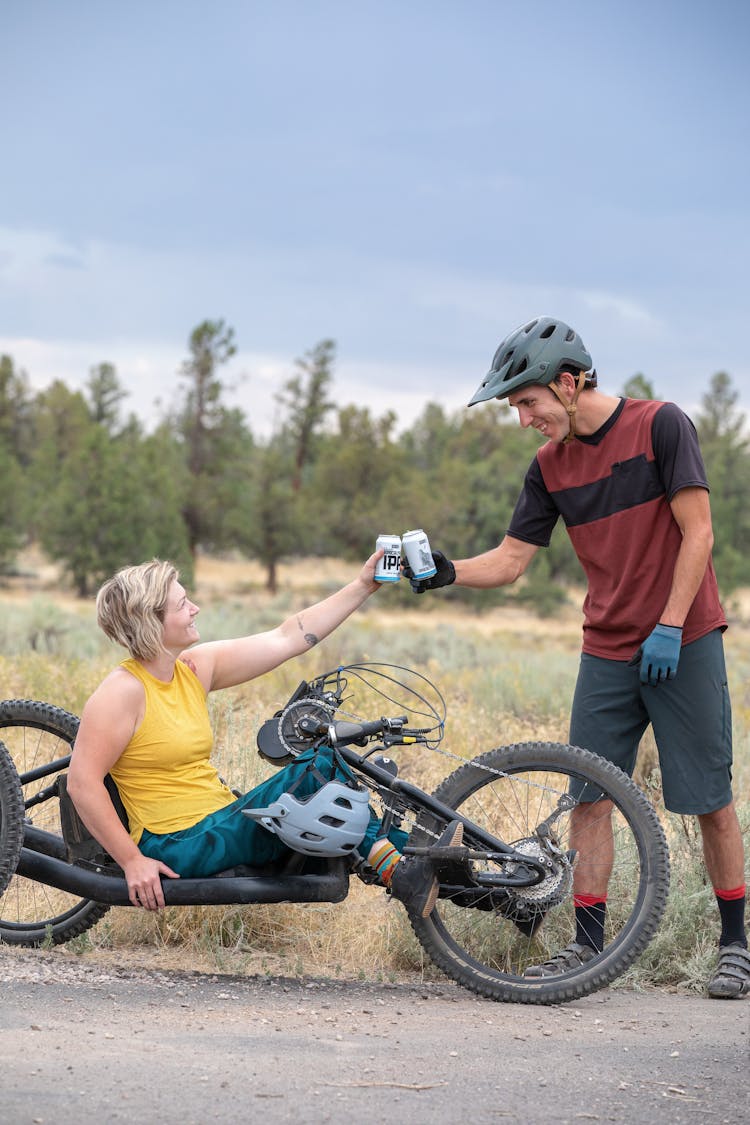 Man And Woman Toasting Beer On The Side Of The Road