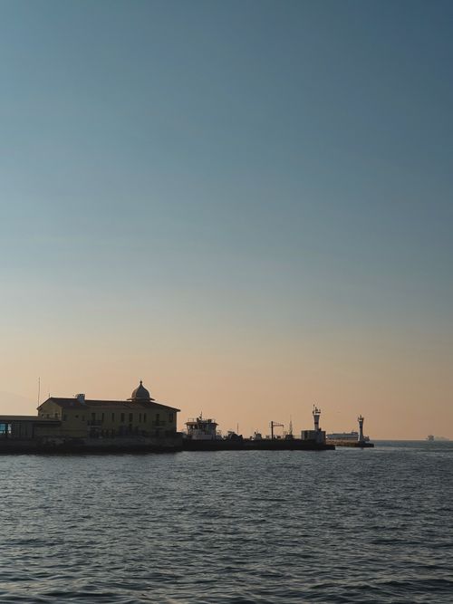 Free Serene view of Izmir's coastline with buildings and calm evening sky. Stock Photo