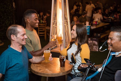 бесплатная Четыре улыбающихся человека возле стола с напитками Стоковое фото