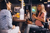 两名女子在酒吧喝酒，微笑着社交