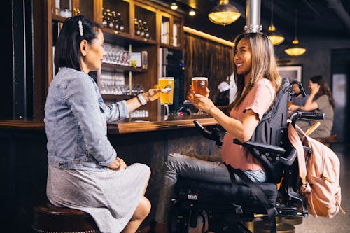 Duas Mulheres Sentadas Segurando Bebidas