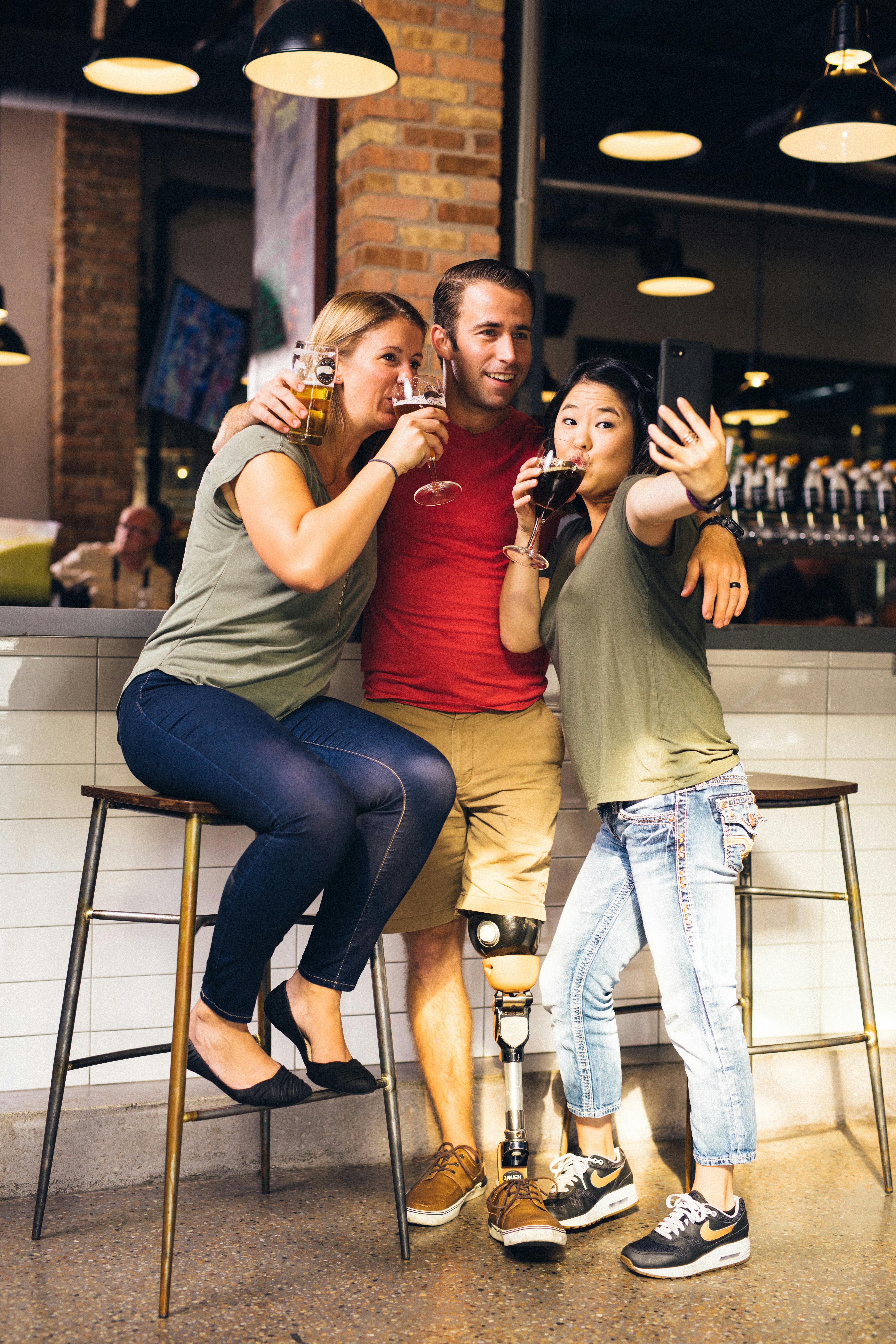 people taking a selfie while drinking beer