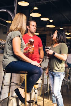 在现代酒吧环境中，三个成年人正在喝酒社交