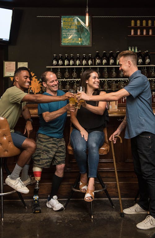 Four People Smiling Holding Glasses with Drinks