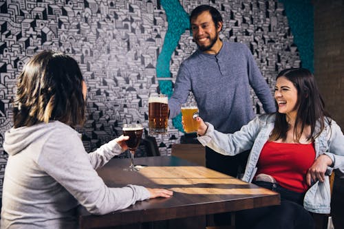 Free People Around a Table Having Fun and Drinking Beer Stock Photo
