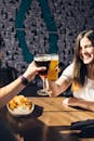 两个朋友在舒适的酒吧里，一边享用饮料和零食，一边分享快乐的时光