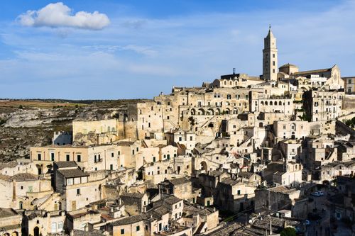 Free Scenic view of Matera's ancient stone buildings under a blue sky. Stock Photo