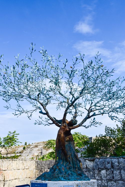 Free A stunning metal olive tree sculpture against a clear blue sky in Apulia, Italy. Stock Photo