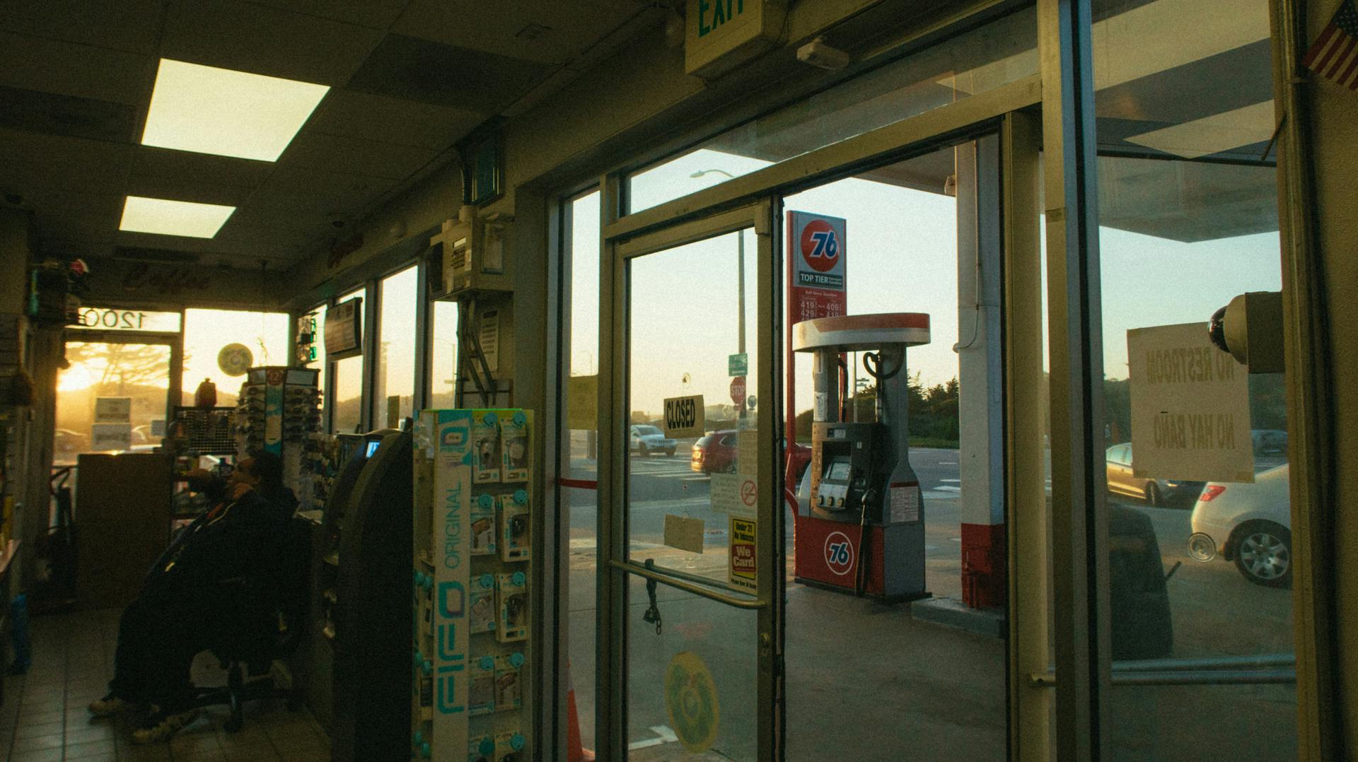 Interior of a gas station showing a window with a view of a gas pump at dusk, creating a nostalgic mood.