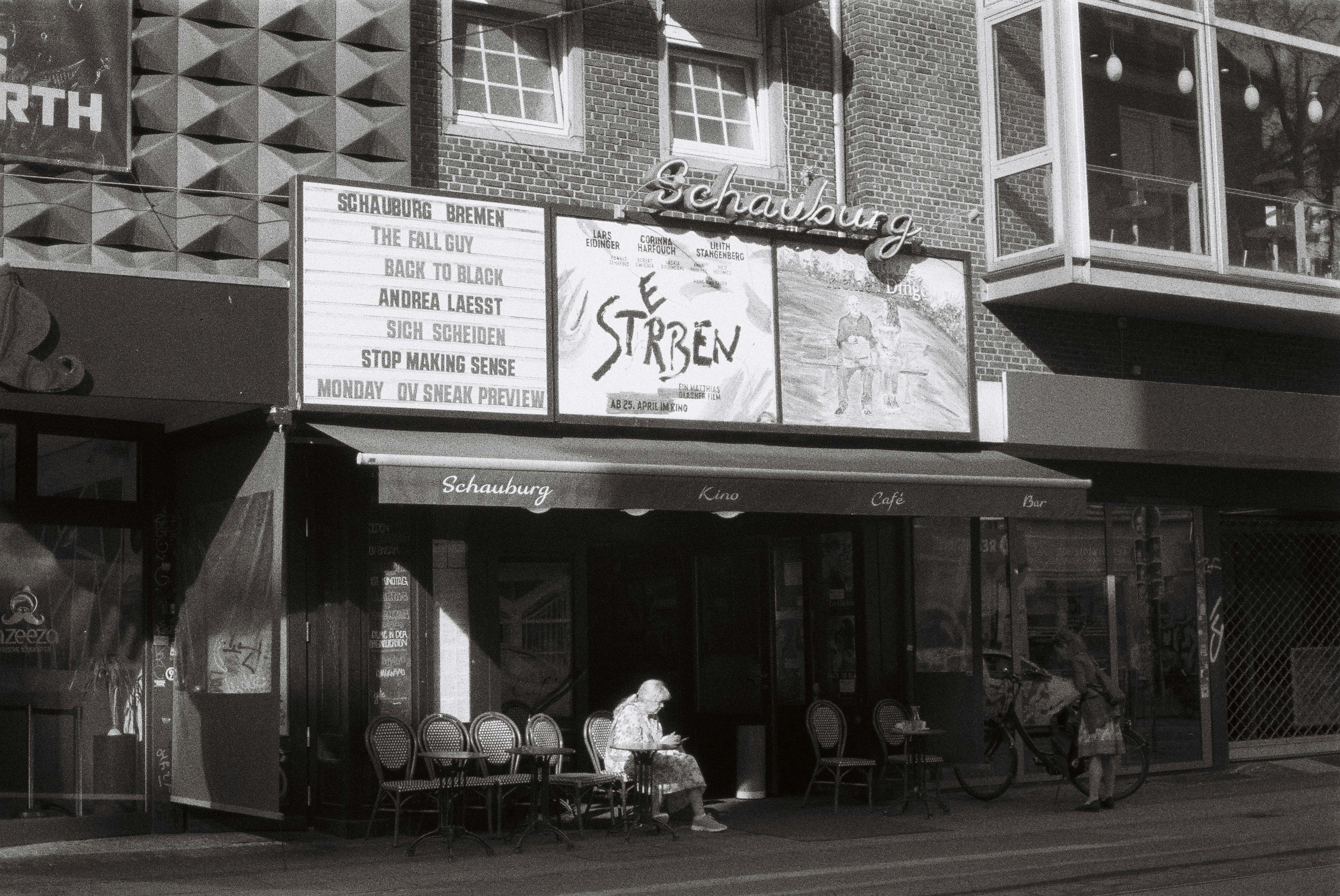 Kostenlos Schwarz-weiße Straßenansicht des Schauburg-Theaters, die das städtische Leben in Bremen, Deutschland, zeigt. Stock-Foto