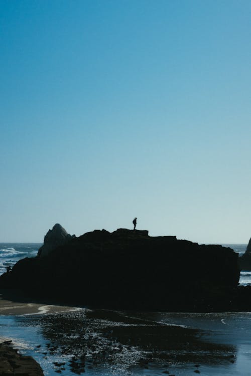 Photo Of Person Standing On Rock