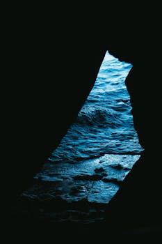 三角形洞穴开口提供了独特的海景视角，突出了光与影的交织