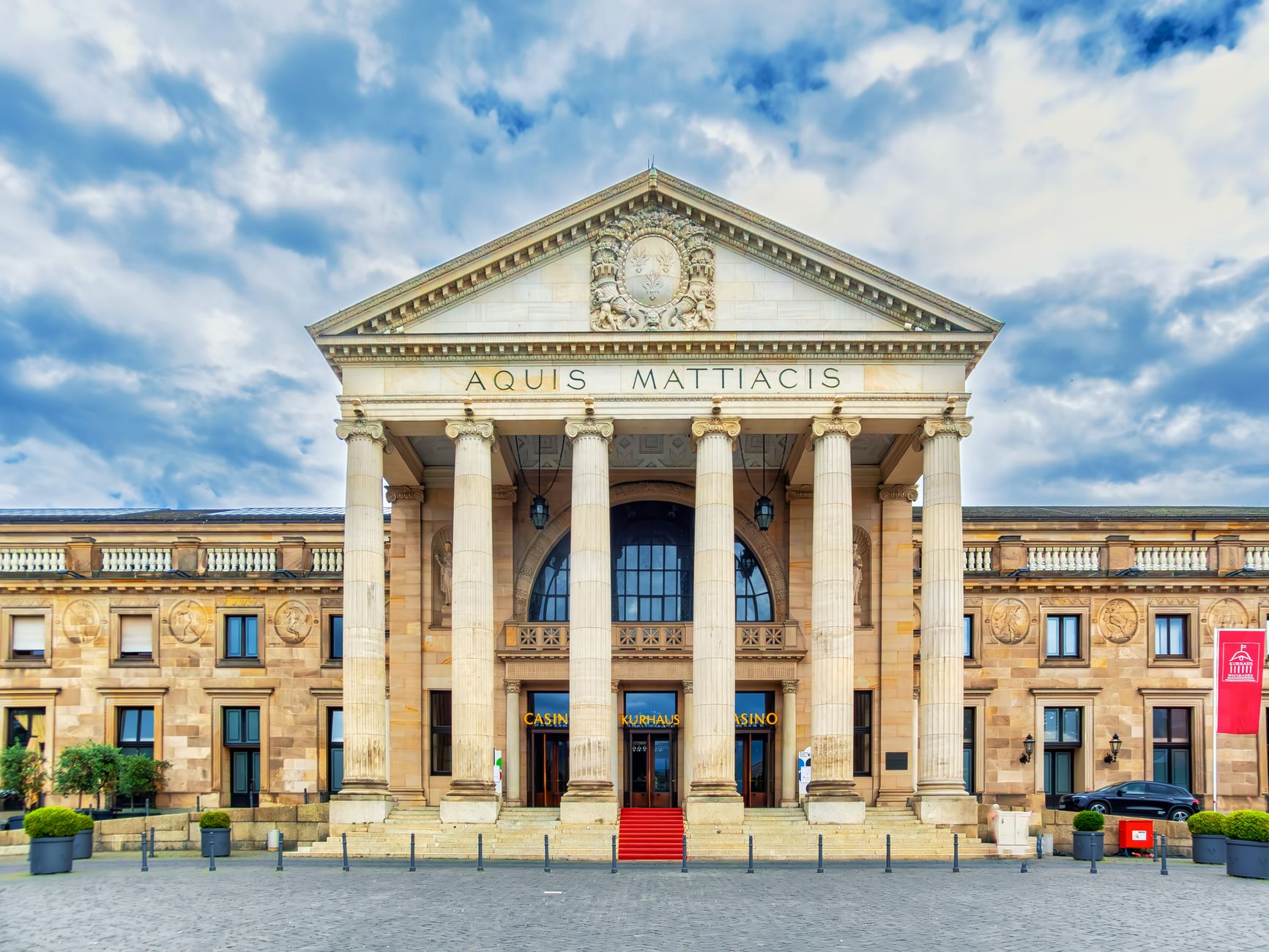 Stunning frontal view of the historic Kurhaus in Wiesbaden, Germany under a dramatic sky.