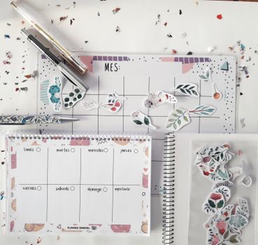 Flat lay of a planner with decorative stickers and stationery for organizing tasks creatively.
