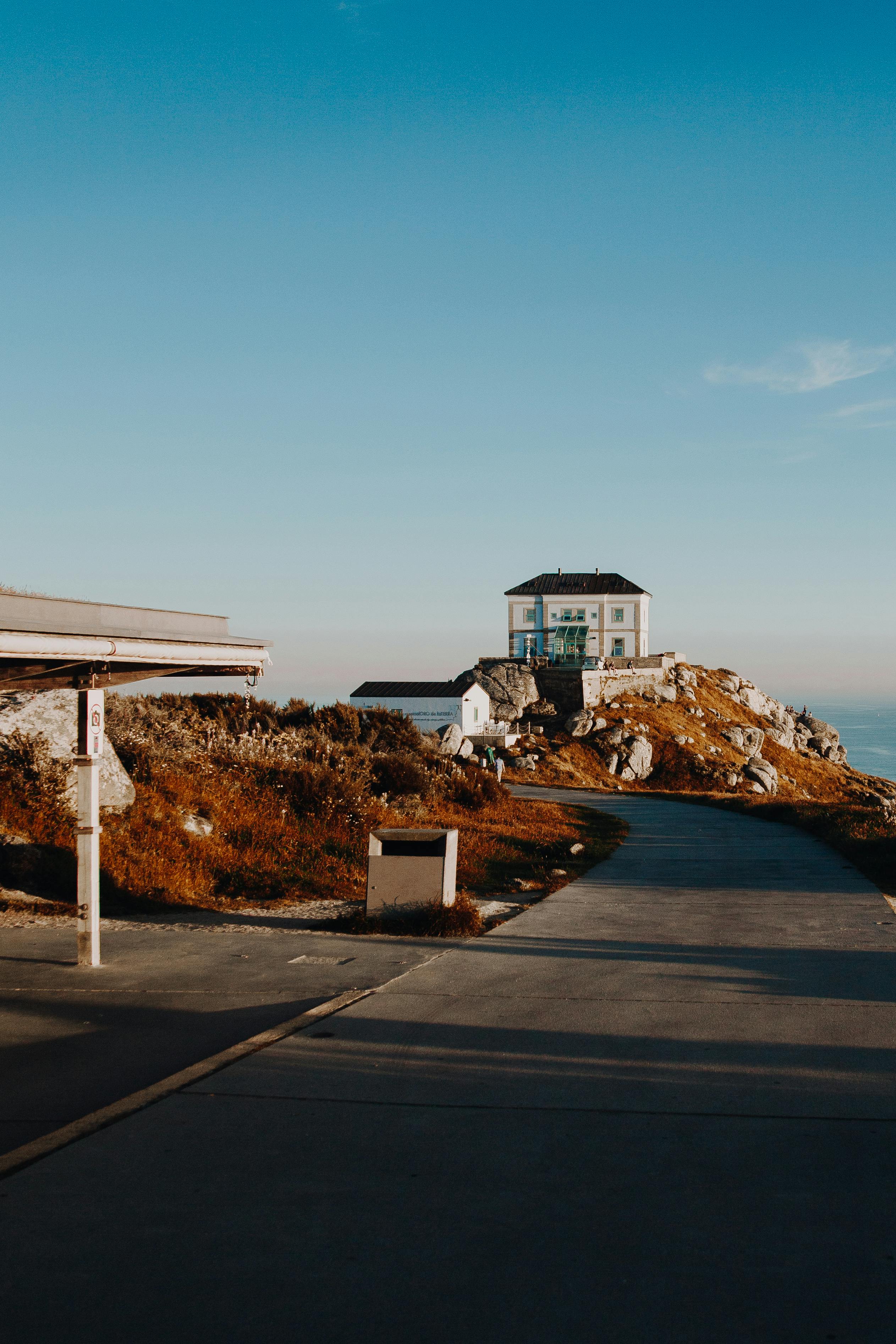 蔚蓝的天空下，一座孤独的房子坐落在海边的小山上