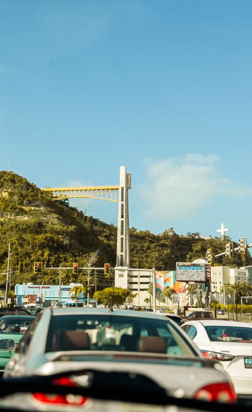 Free Busy urban traffic with view of a modern bridge and hill under clear blue skies. Stock Photo