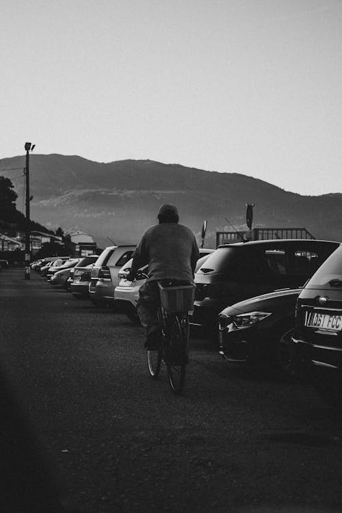 Grayscale Photo Of A Man Riding A Bicycle