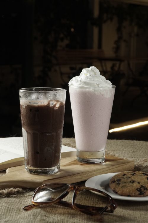 Free Delicious chocolate and strawberry milkshakes with whipped cream, perfect for a relaxing day. Stock Photo