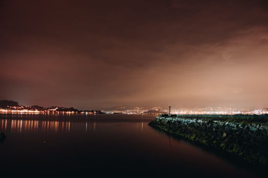 宁静海湾的夜间景观映照着城市灯光，非常适合旅行和自然爱好者