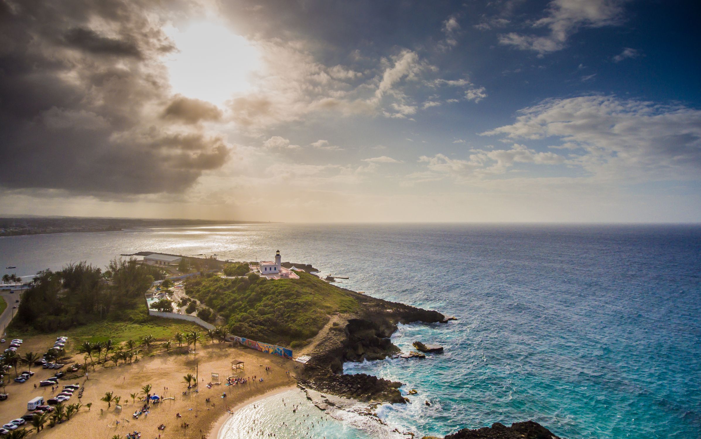 Caleb Oquendo Aerial view of the Rincon lighthouse overlooking a tropical beach in Puerto Rico