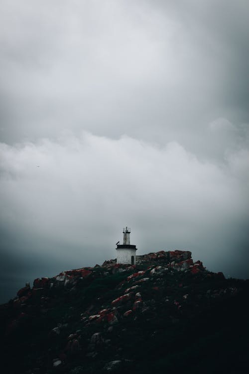 灰色の空の下の山の灯台