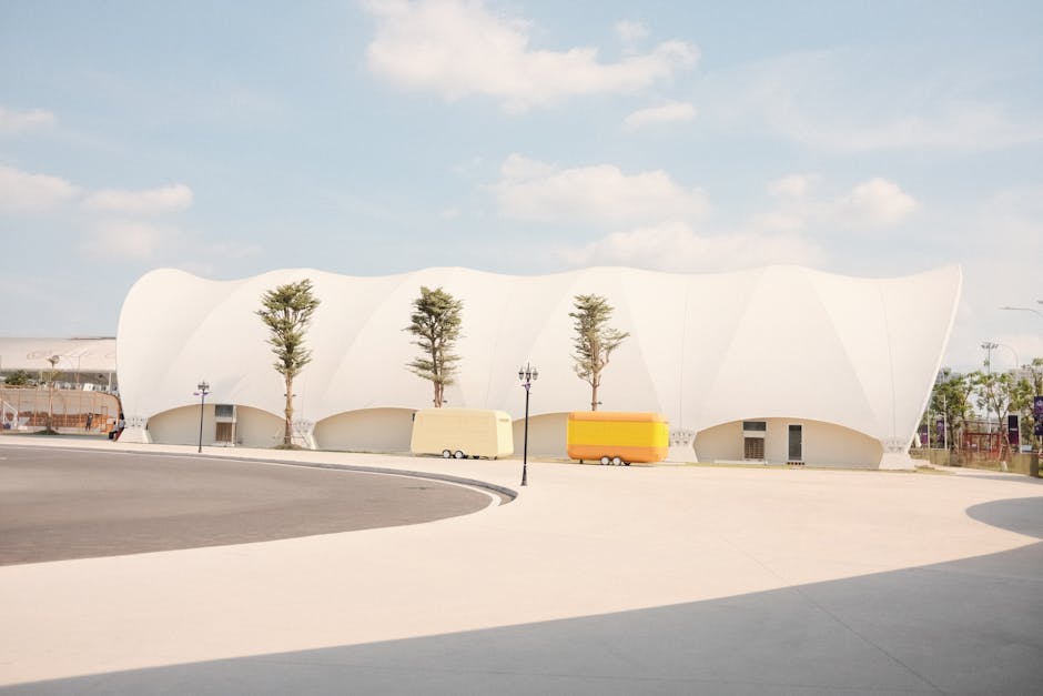 Contemporary architecture with sleek curves and vibrant colors in a sunny setting.