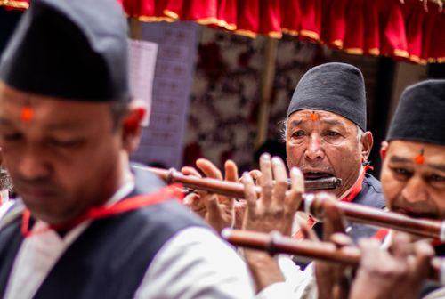 Free A group of traditional musicians playing flutes during a cultural event, wearing traditional attire. Stock Photo