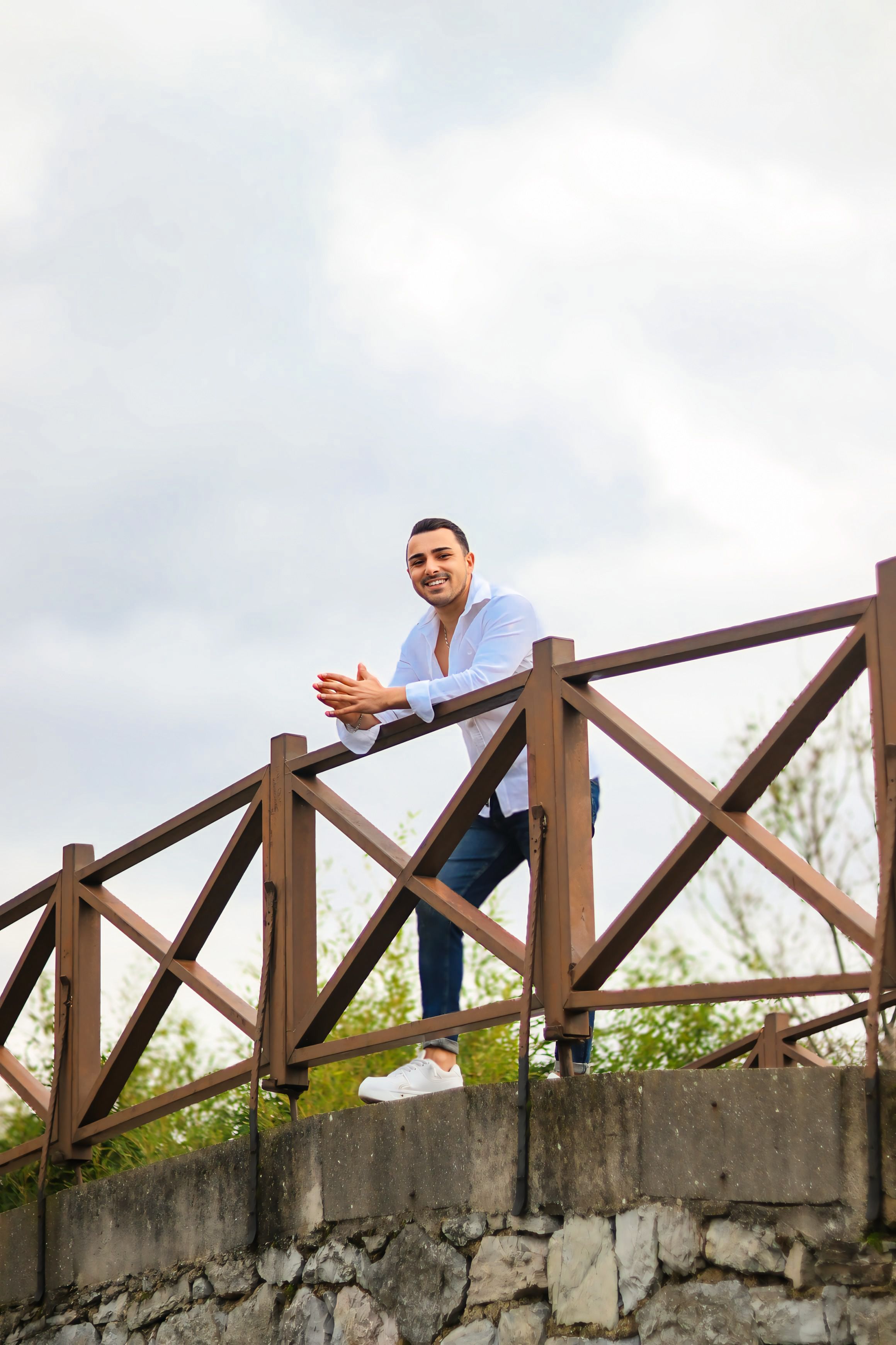 Smiling Man Leaning On Rustic Wooden Fence Outdoors Free Stock Photo