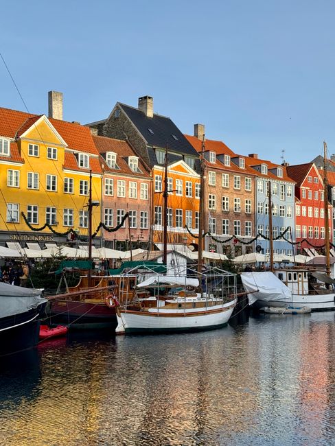 Charming waterfront view of colorful buildings and boats in Nyhavn, Copenhagen.