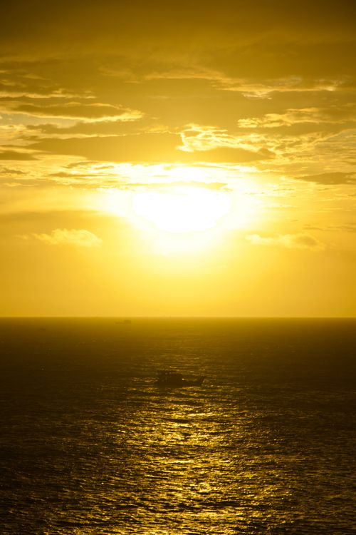 Free A breathtaking golden sunset over the tranquil ocean, creating a serene atmosphere. Stock Photo